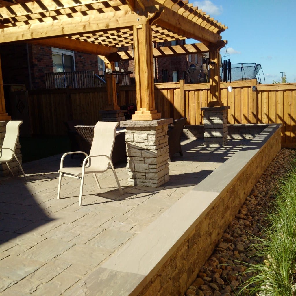 Pergola and stone patio in a completed backyard