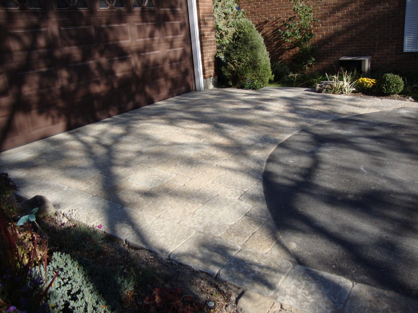 Interlock walks, garden beds and lawn across a residential property
